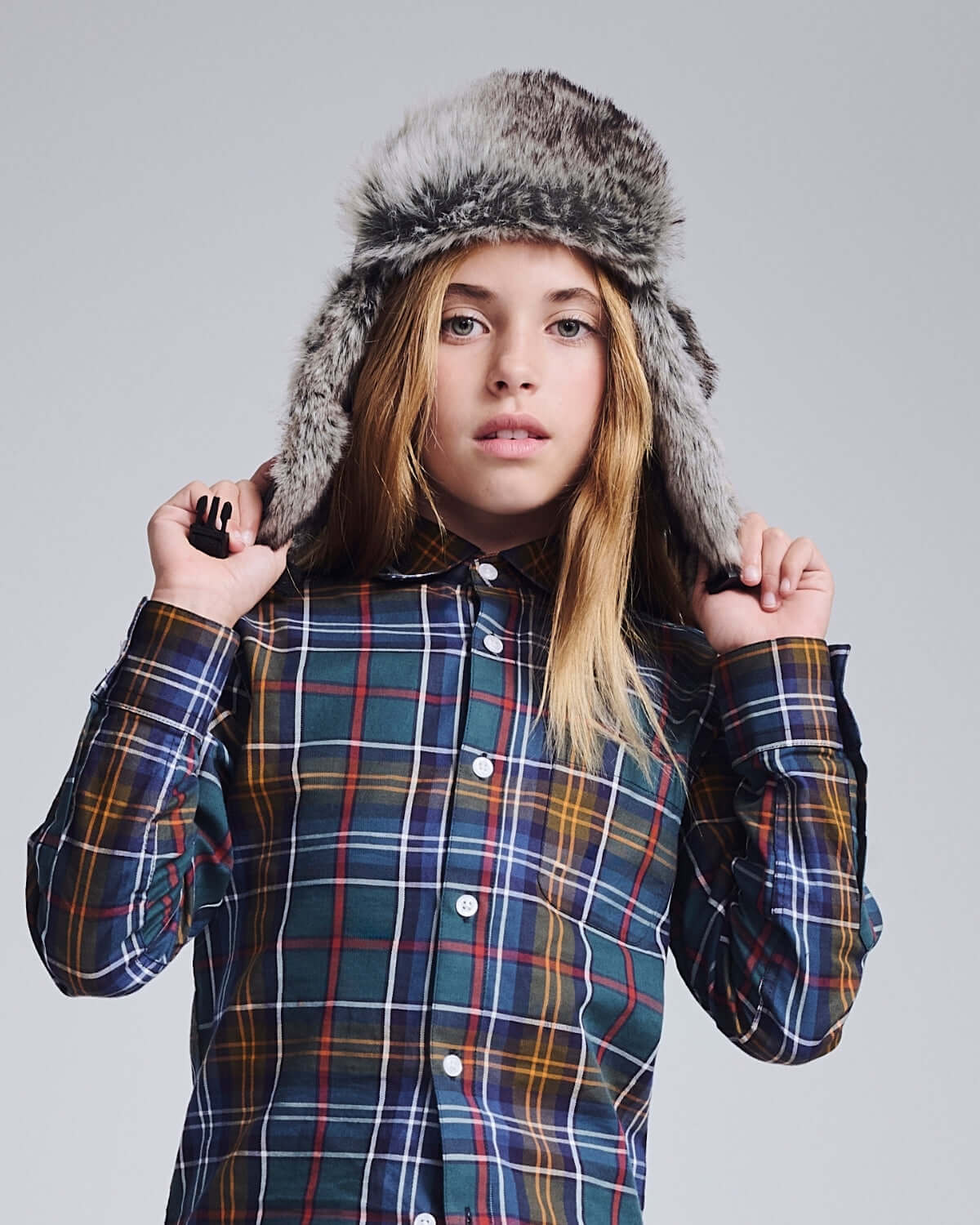 Light Grey Muscle Trapper worn by a model in plaid shirt with faux fur details, showcasing stylish rugged comfort.