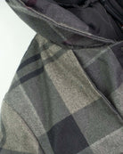 Close-up of the Grey Plaid New Gotham Coat showing its structured design and cozy hoodie.