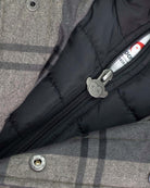 Close-up view of the inner zipper of the Grey Plaid New Gotham Coat showcasing its warm lining.