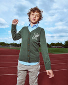 Boy wearing Hunter Green Obi Cardigan on a track, showcasing its stylish look and comfortable fit for active kids.