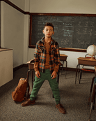 Boy wearing Forest Green Highland Sweatpants and a plaid flannel shirt in a classroom setting.