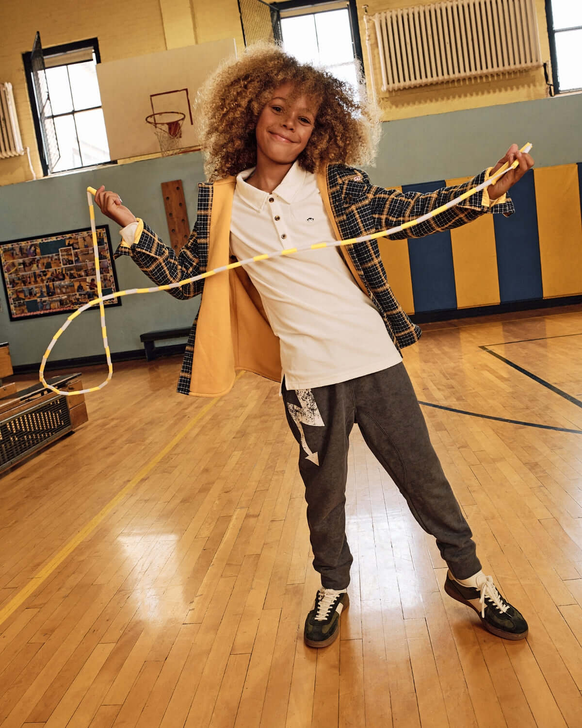 Child wearing a White Parker Polo, playing in a gym with a skip rope, showcasing casual style and comfortable fit.