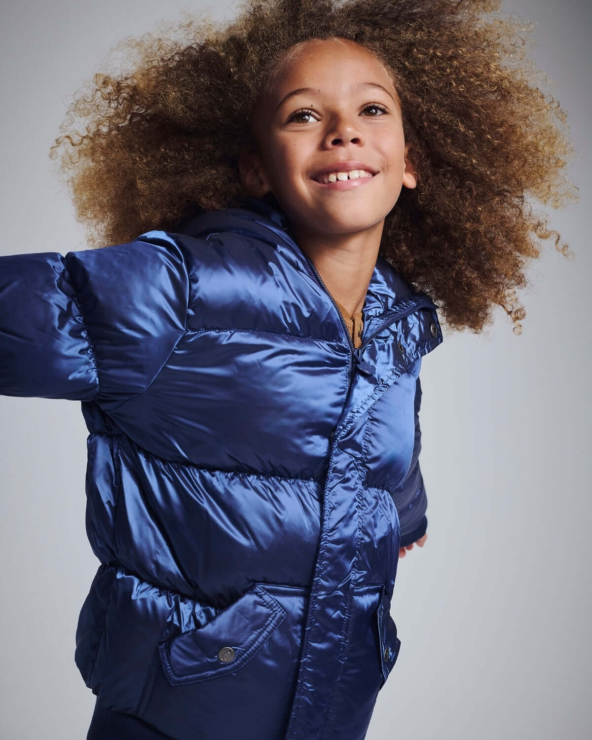 Happy child wearing a stylish Navy Blue Puffy Coat, perfect for winter outdoor adventures.