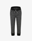 A pair of children's jogger pants featuring a black and gray houndstooth pattern, a solid black elastic waistband with a gray drawstring, and black ribbed cuffs at the ankles, shown against a plain white background.