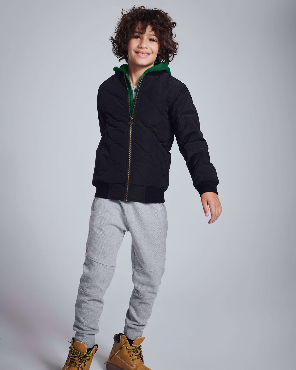 Child wearing Novelty Grey Heather Sideline Sweatpants with a black jacket and stylish boots.