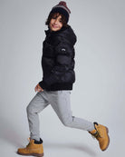 Child wearing Novelty Grey Heather Sideline Sweatpants with a black puffer jacket and yellow boots.