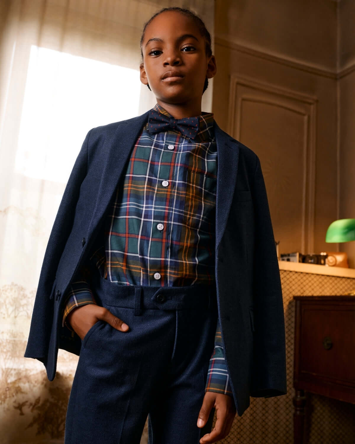 Stylish boy wearing a navy suit and Navy Darts Bow Tie, showcasing a classic and fun look.