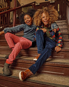 Two kids laughing on stairs wearing Cherry Blue Check Snow Fleece Shirt and stylish pants, showcasing a fun and cozy look.