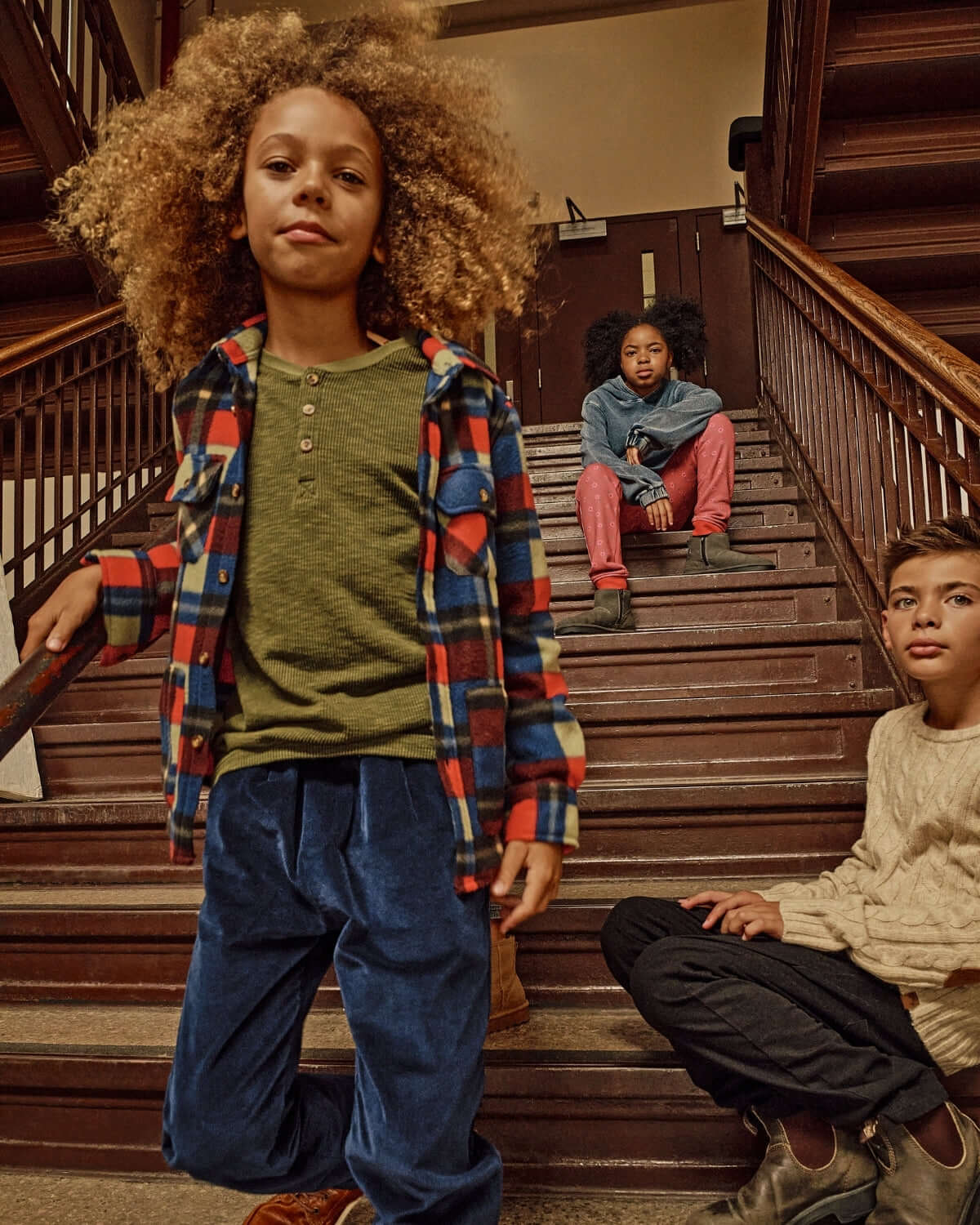 Kids wearing stylish outfits on stairs, featuring Cherry Blue Check Snow Fleece Shirt.