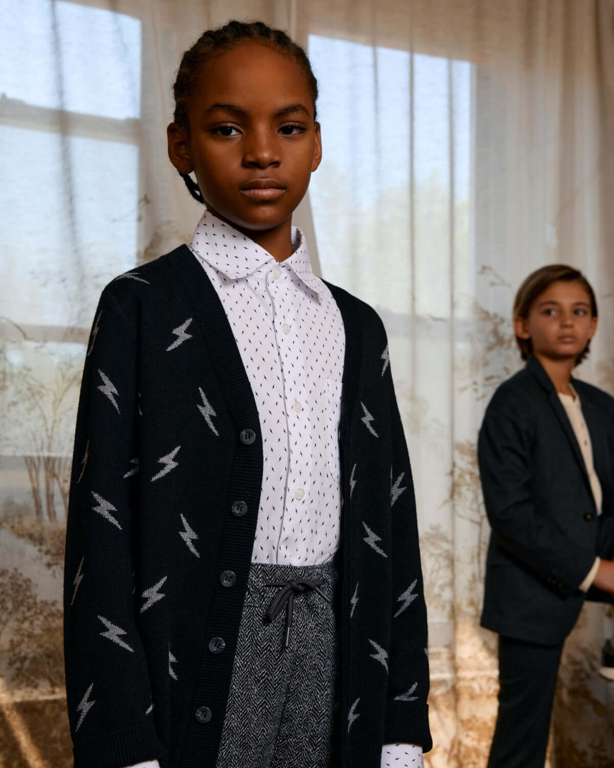 Electrifying Standard Button Down worn under a lightning bolt cardigan, showing stylish kids' fashion in natural light.