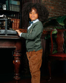 Child wearing High Club Standard Button Down shirt styled with a green cardigan, standing by a vintage desk.