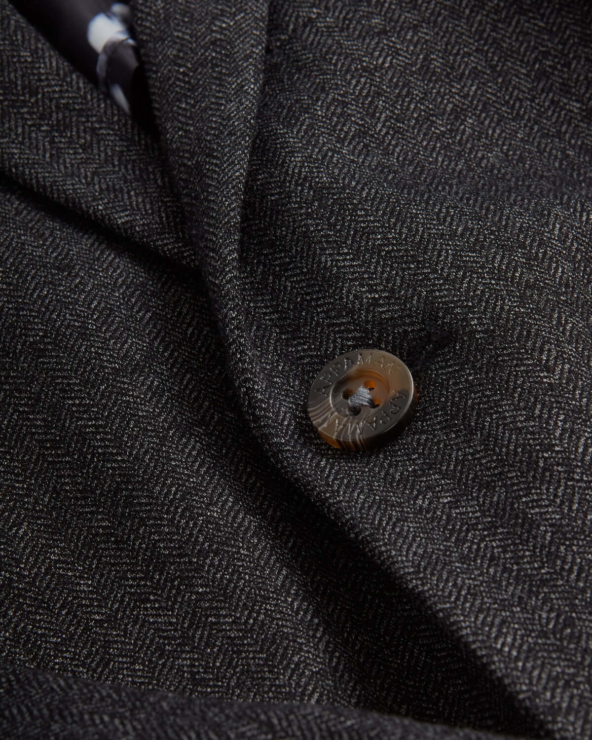 Close-up of the Black Herringbone Stretchy Mod Suit fabric and button detail, showcasing its stylish design.
