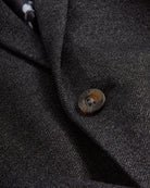 Close-up of the Black Herringbone Stretchy Mod Suit fabric and button detail, showcasing its stylish design.
