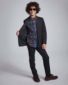 Boy wearing a Black Herringbone Stretchy Mod Suit with a colorful shirt, stylish sunglasses, and a confident pose.