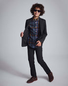 Boy wearing Black Herringbone Stretchy Mod Suit with plaid shirt and sunglasses.