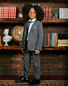 Noir Micro Plaid Stretchy Mod Suit worn by a child with curly hair, posing in a stylish room.