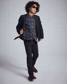 Boy confidently walking in Black Herringbone Stretchy Suit Pants and stylish sunglasses, showcasing a trendy outfit.