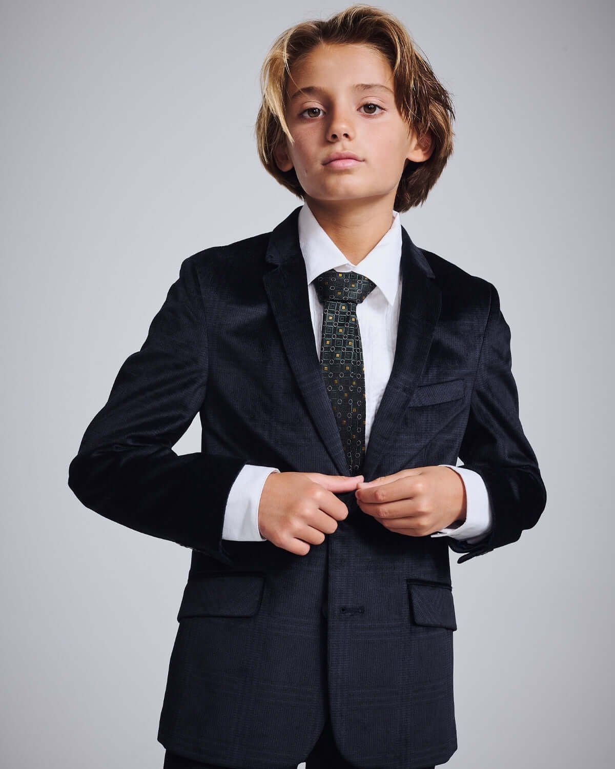 Midnight Velvet Plaid Blazer worn by a boy with a tie, showcasing sharp tailoring and luxury style.