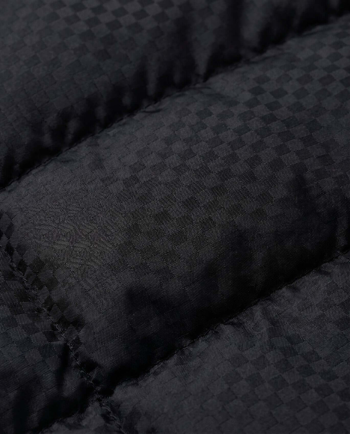 Close-up of the fabric texture on the Black Checkerboard Turnstile Jacket showcasing the bold checkerboard pattern.