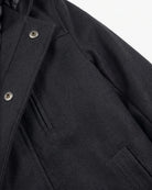 Black Urban Gotham Coat showing sleek black fabric and sharp tailoring details.