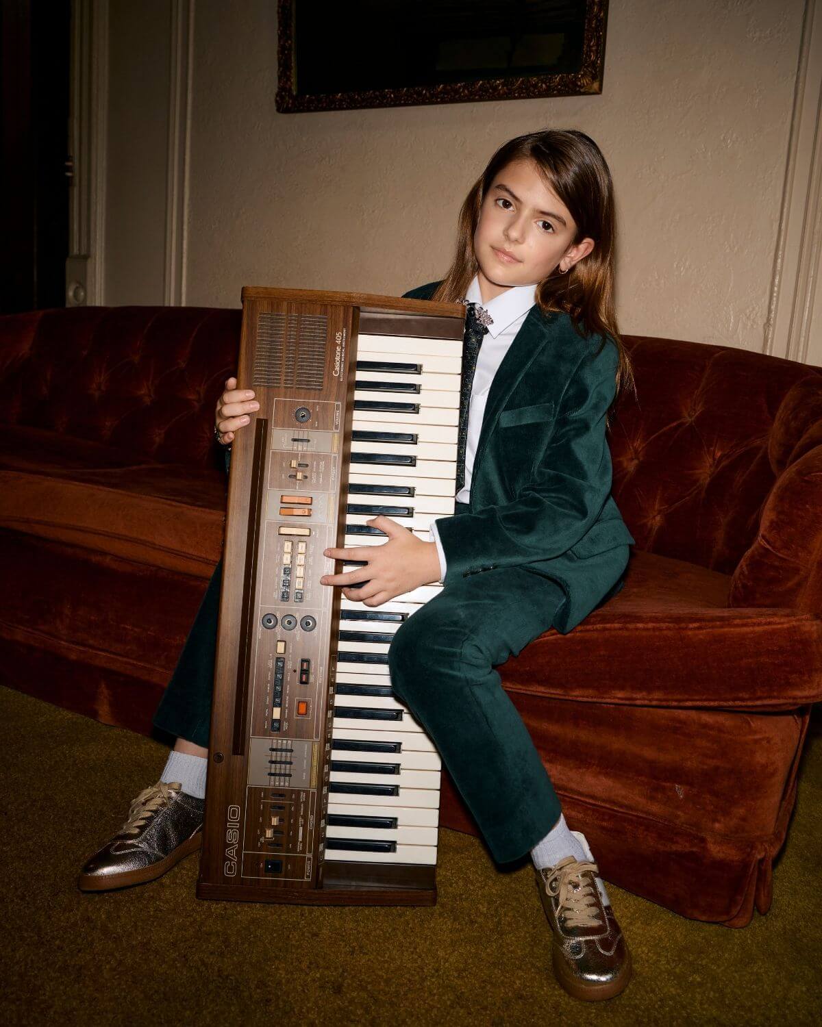 Child wearing Evergreen Velvet Suit Pants while playing a vintage keyboard.