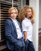 Two children in stylish outfits, showcasing the White Beach Shirt for summer adventures.