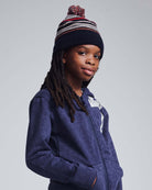 Child wearing a Navy Blue Wind Hat with pom pom, styled in a cozy navy hoodie.