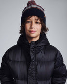 Boy wearing a Navy Blue Wind Hat with a pom pom, styled for outdoor adventures in winter clothing.