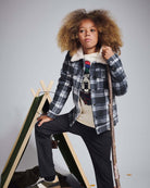 Child wearing a Winter Dog Graphic Long Sleeve Tee, layered under a checkered jacket, with a playful dog design.