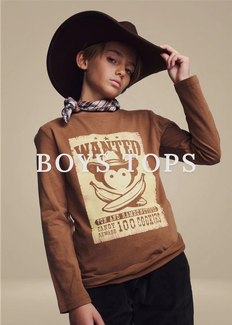 A boy wearing a brown long-sleeve graphic sweatshirt, a brown cowboy hat, and a plaid neckerchief against a plain beige studio background. Large white text across the center reads 'BOYS TOPS'.