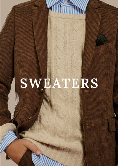 A close-up of a person wearing a beige cable-knit sweater vest over a brown corduroy blazer, with a blue and white striped dress shirt visible at the collar and cuffs. The word 'SWEATERS' is overlaid in large white text across the center.