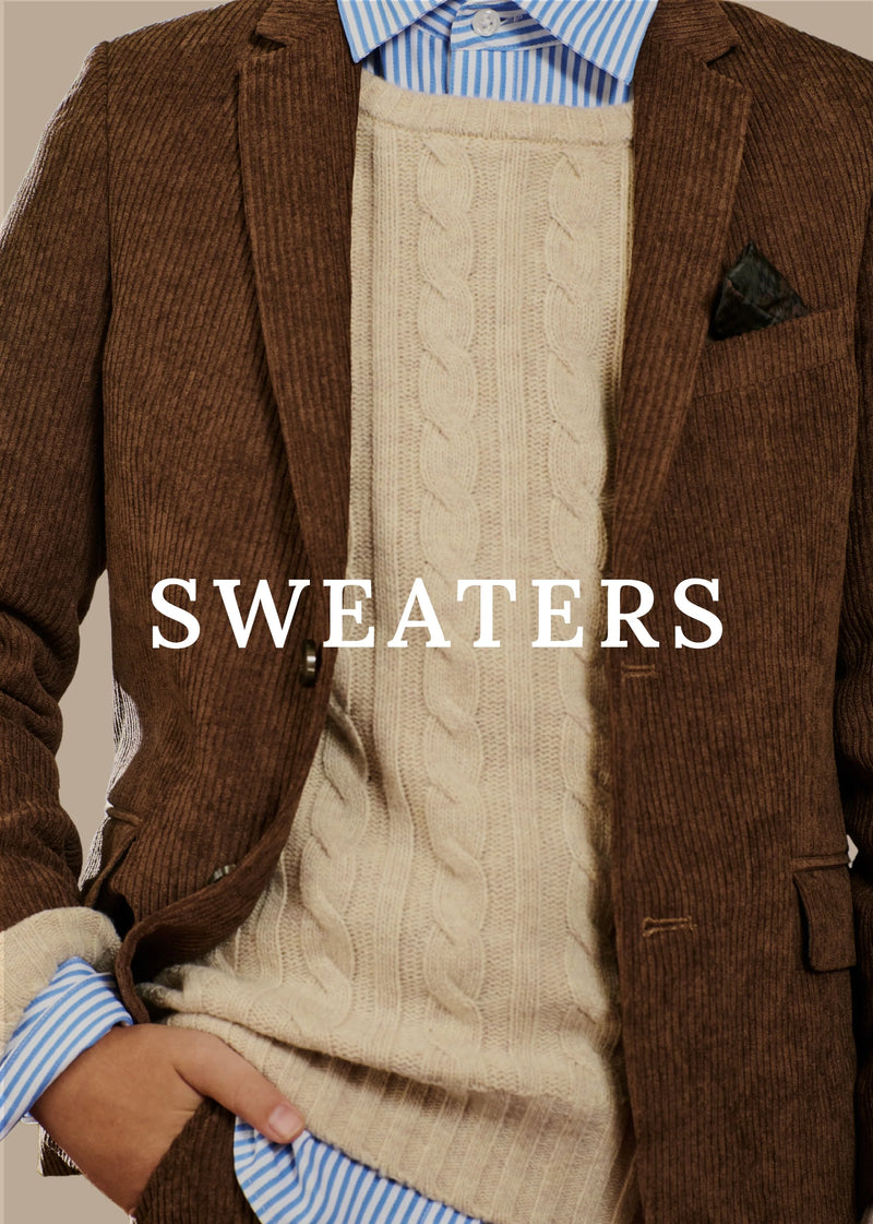 A close-up of a person wearing a beige cable-knit sweater vest over a brown corduroy blazer, with a blue and white striped dress shirt visible at the collar and cuffs. The word 'SWEATERS' is overlaid in large white text across the center.