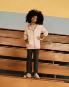 A child wearing Olive Flare Leggings paired with a stylish hoodie, showcasing comfort and playful fashion.