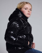 Glitter Black Slim Puffy Coat on a girl, showcasing its shiny black material and stylish design for chilly days.