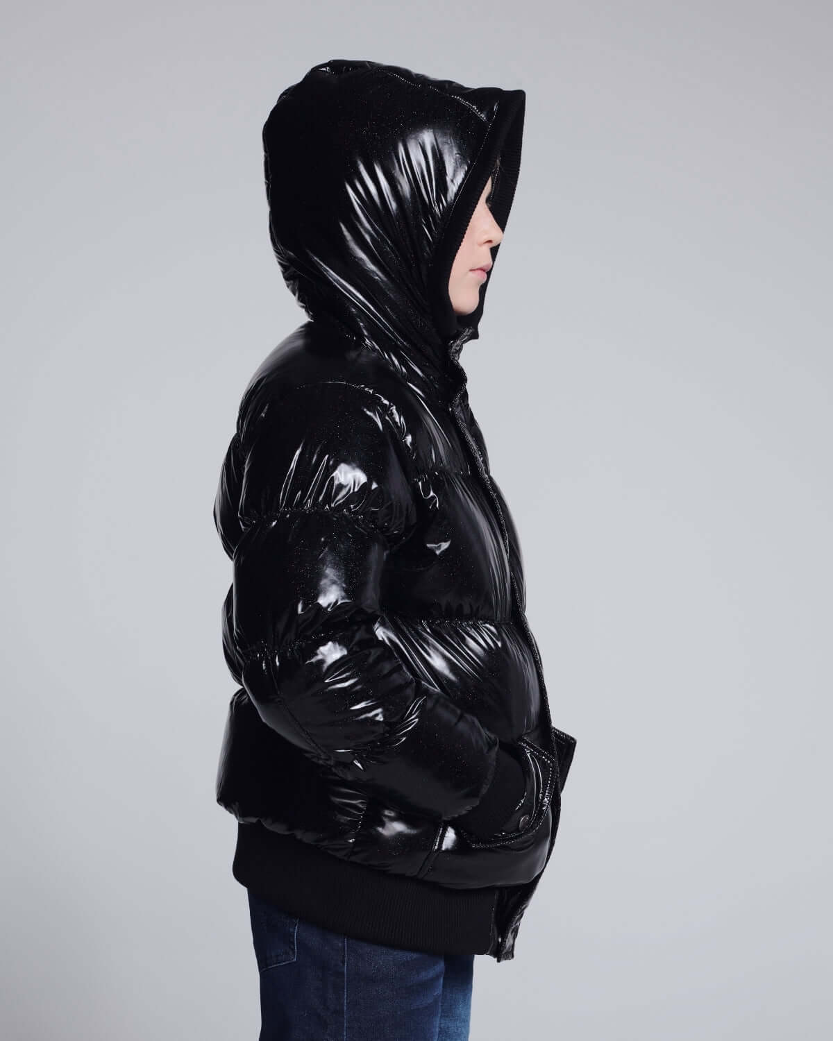Glitter Black Slim Puffy Coat displayed on a child, showcasing its shiny black exterior and hood.