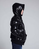 Glitter Black Slim Puffy Coat displayed on a child, showcasing its shiny black exterior and hood.