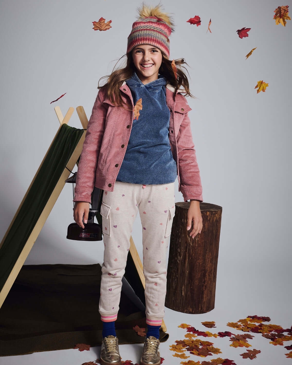 Girl wearing Heart Oatmeal Cozy Cargo Joggers with a pink jacket and beanie, surrounded by autumn leaves.