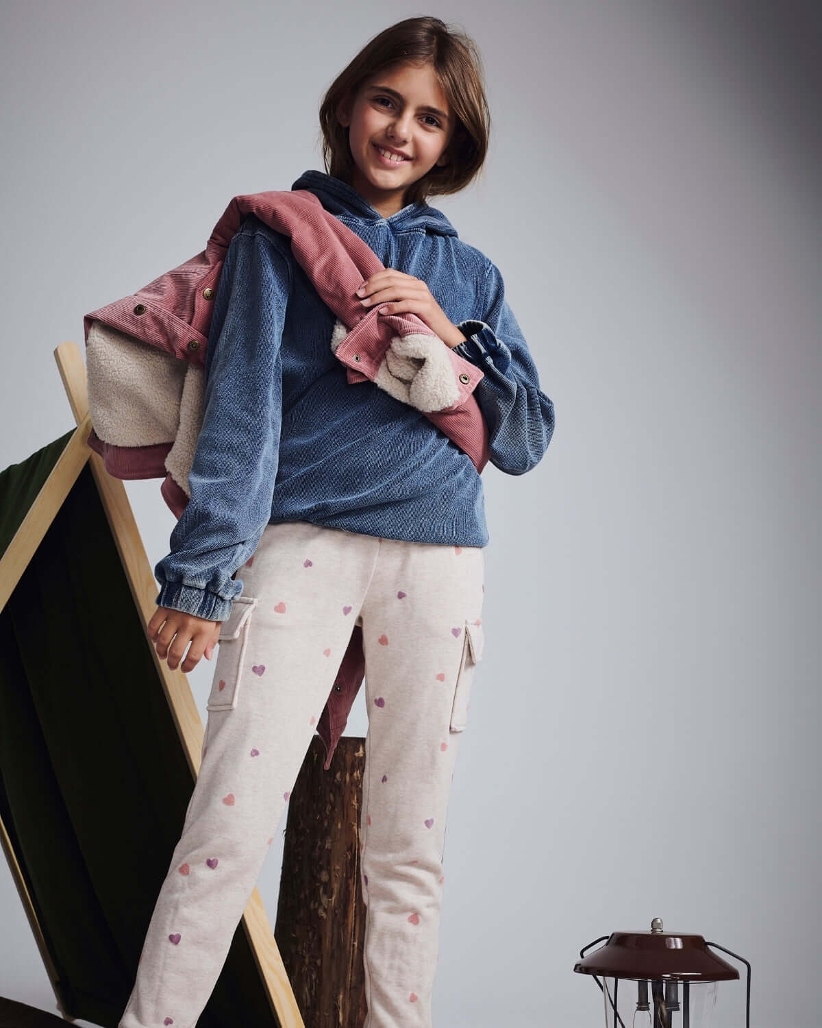 A model wearing Heart Oatmeal Cozy Cargo Joggers with a blue hoodie and jacket against a cozy background.