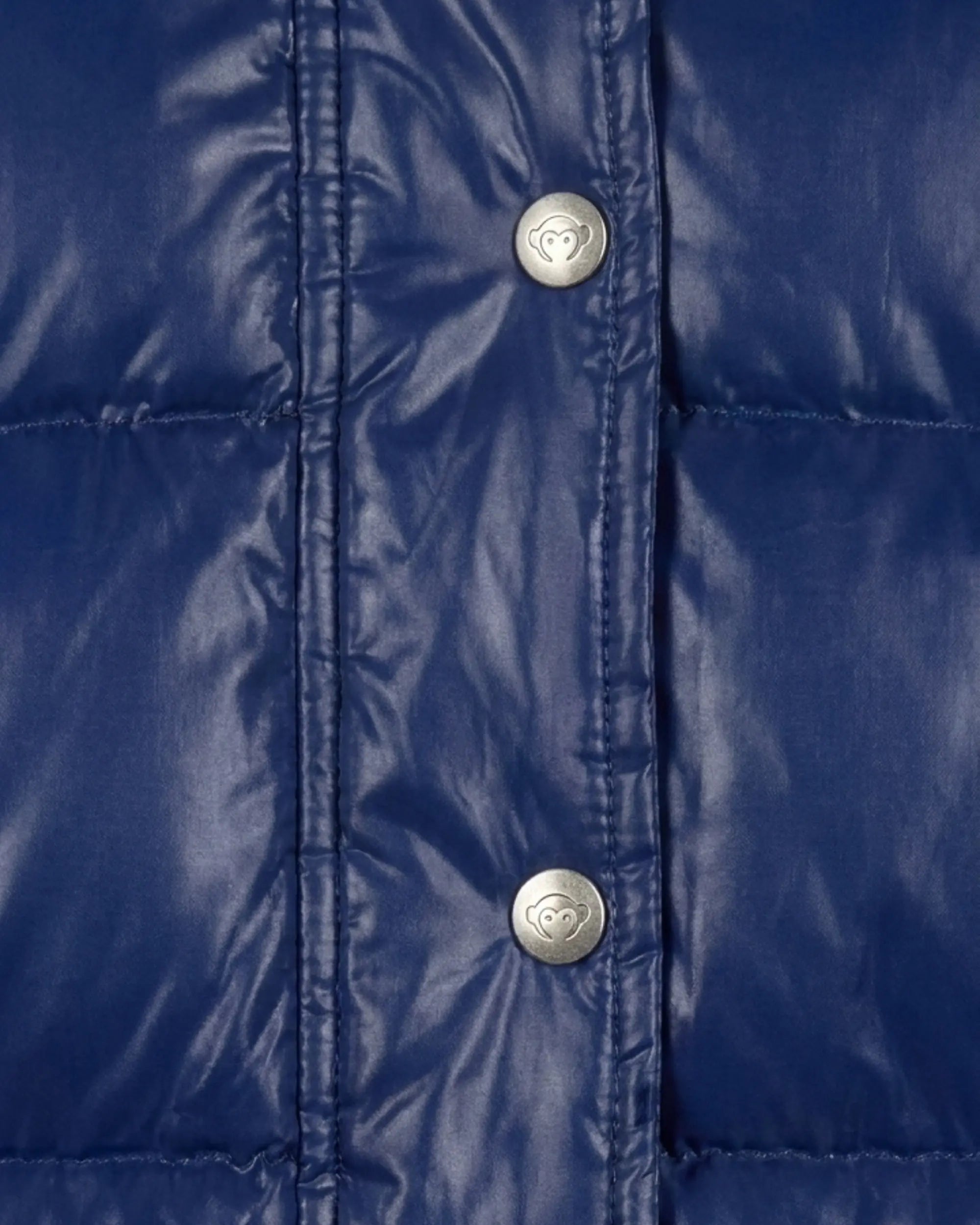 Close-up of a shiny royal blue quilted puffer jacket with silver snap buttons featuring a heart logo.