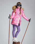 Girl wearing Navy Primrose Leggings with pink ski jacket and goggles, ready for winter activities.