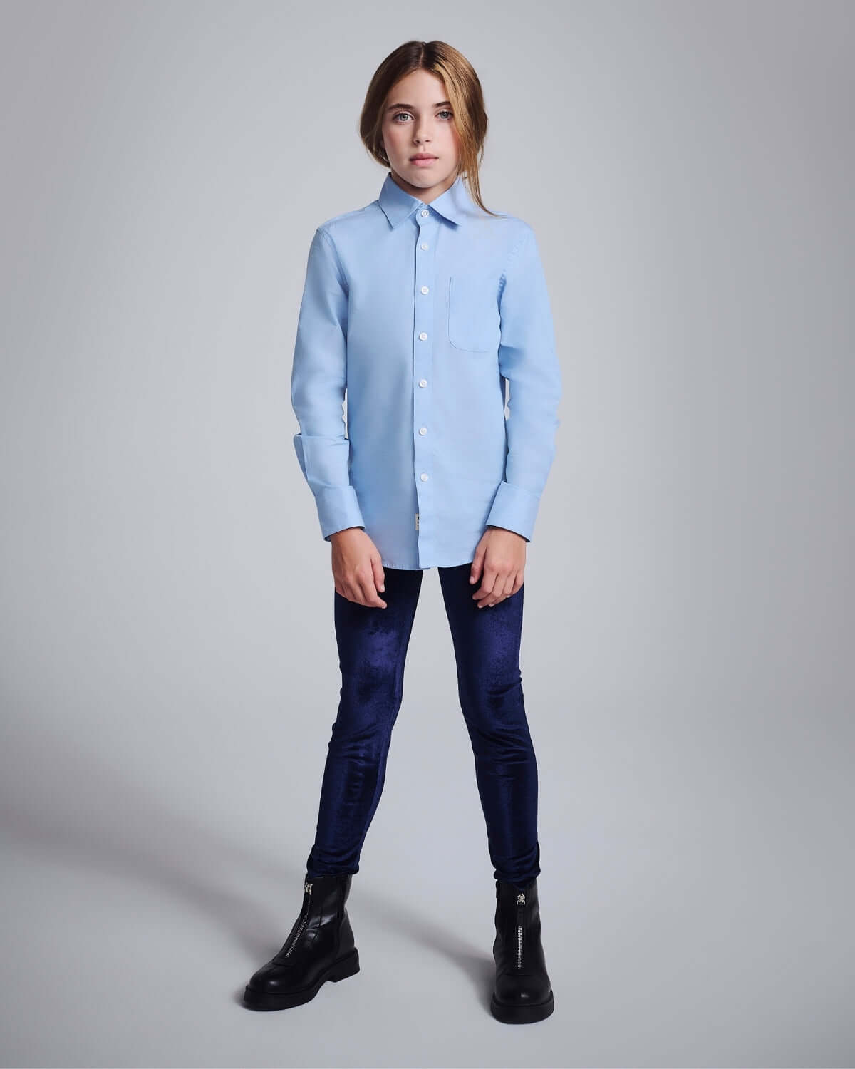 Girl wearing Navy Twilight Leggings with a light blue shirt and black boots.