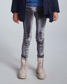 Child wearing Silver Frost Legging with beige boots, showcasing shiny, stretchy comfort in a stylish look.