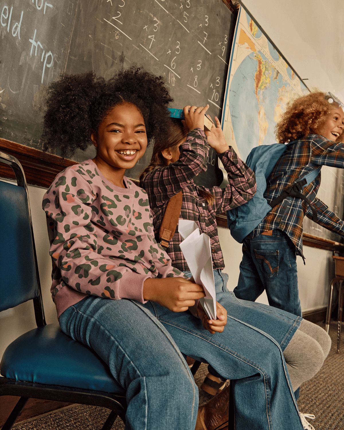 Kids wearing the Leopard Ruby Sweatshirt in a classroom, showcasing trendy leopard print and happy expressions.