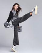 Girl in mid-action wearing Black Glitter Lily Seamed Sweatpants, showcasing style and comfort during outdoor play.