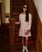 A girl wearing a pink dress, posed with a teapot. Appaman Fall/Winter 2026 collection.