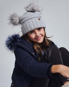 Girl wearing a Shiny Silver Mia Faux Fur Pom Beanie with two pom poms, cozy winter outfit.