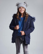 Navy Sparkle Middie Puffer Coat worn by a smiling girl with a cozy hat, perfect for winter outings.
