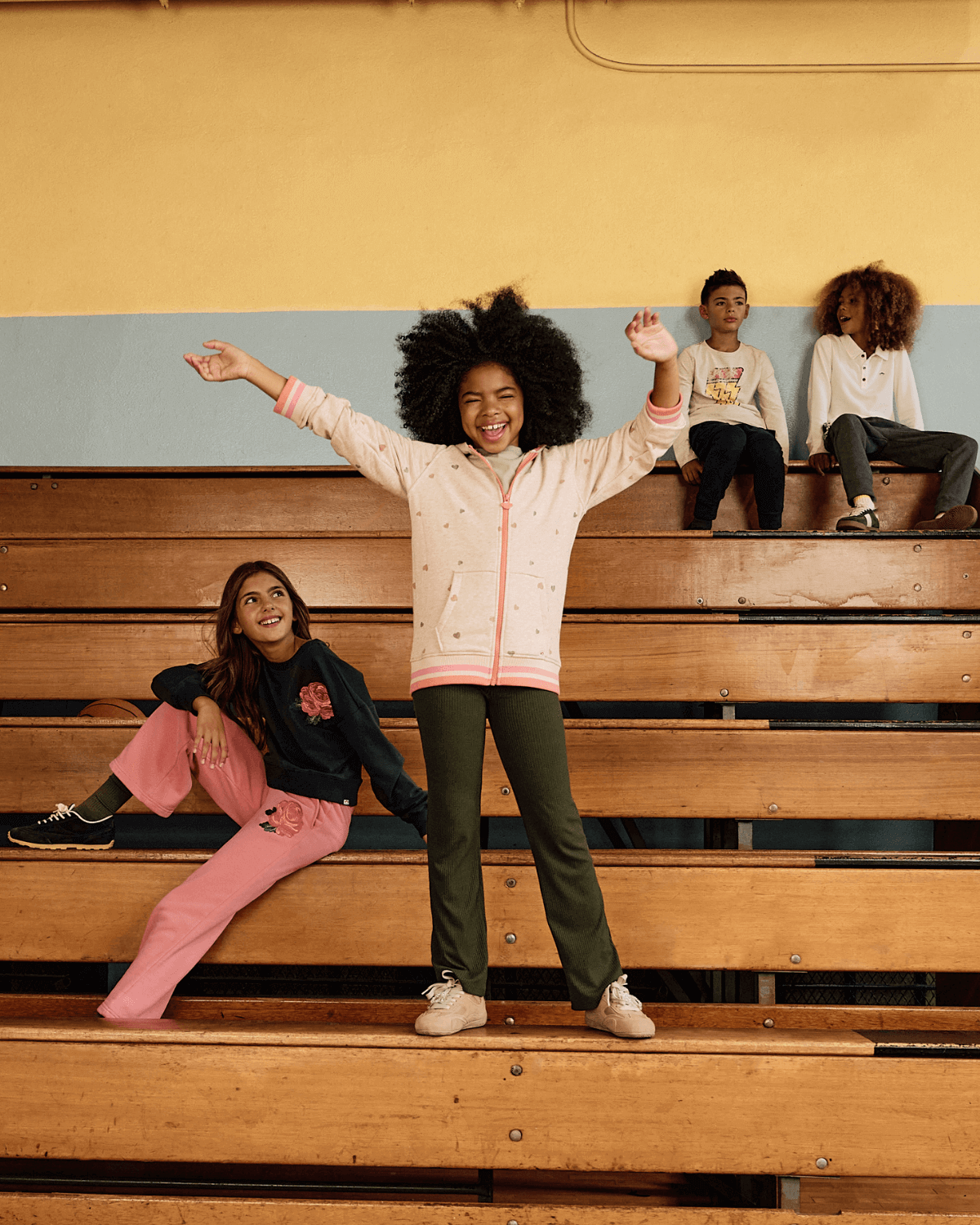 Heart Oatmeal Cozy Raglan Hoodie worn by kids on bleachers, showcasing playful style and comfort.