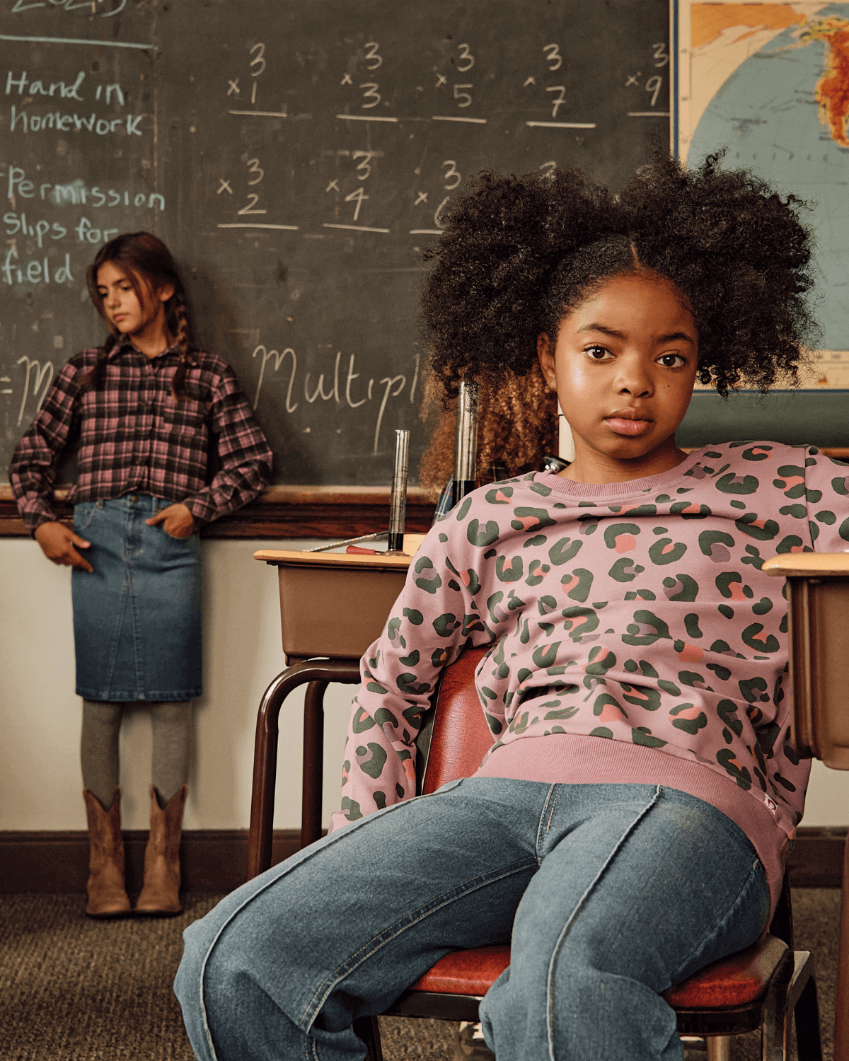 Girl wearing Leopard Ruby Sweatshirt in a classroom setting, showcasing its trendy lilac leopard print.