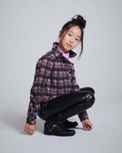 Pink Plaid Polly Cropped Flannel styled on a girl in a crouched pose, featuring a classic collar and playful plaid design.